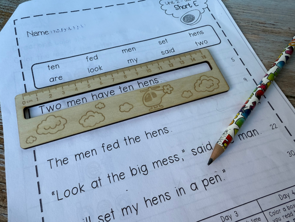 Wooden ruler with cloud design on a worksheet with text and a pencil.